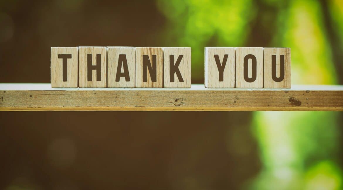 alexas fotos pnGjbJEmU3o unsplash 1 Wooden blocks spelling "THANK YOU" on a wooden surface, with a blurred green background creating a warm, appreciative atmosphere.